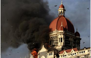 Flames and smoke gush out of the historic Taj Mahal Hotel in Mumbai on Thursday, one of the sites of attacks by alleged militant gunmen. (AFP)