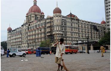 <p>An Indian worker sweeps the street in front of the Taj Mahal Hotel in Mumbai early November 30, 2008. (AFP)</p>