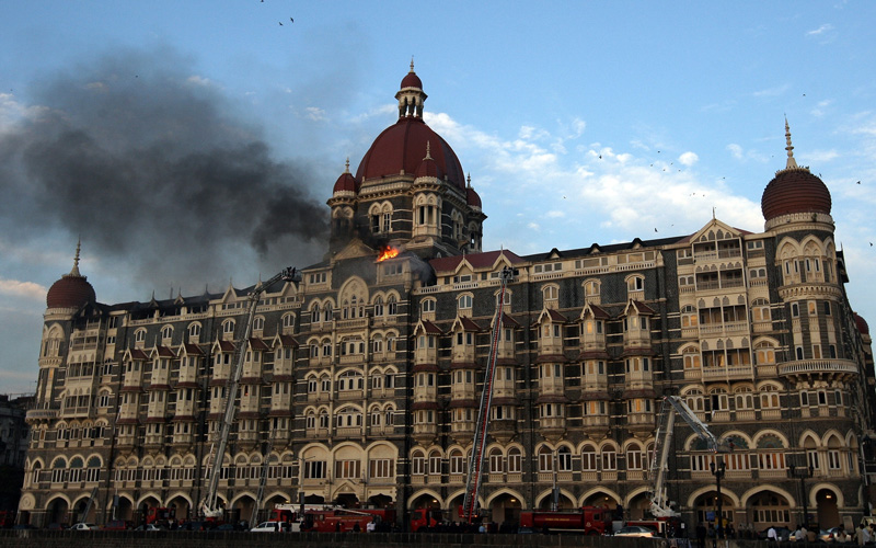 In this picture taken on November 27, 2008, flames rush out of the Taj Mahal Hotel in Mumbai, during an attack by suspected terrorists. Mohammed Ajmal Amir Kasab, on trial in India for being one of the 10 gunmen who attacked Mumbai in 2008, is a school dropout said to have taken part in the bloodiest episode of the deadly siege. The 22-year-old Pakistani national is accused of being one of two heavily-armed gunmen who opened fire and threw hand grenades at the city's main railway station on November 26, 2008, killing 52 and wounding more than 100. (AFP)