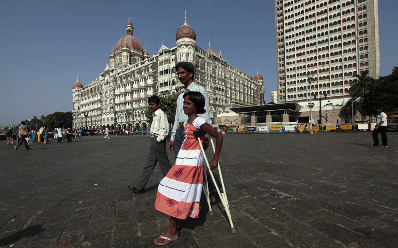 Devika Rotwan, who was shot in her leg during the Mumbai attacks in 2008, walks by the landmark Taj Hotel in Mumbai, India, Monday, May 3, 2010. The verdict in the trial of Mohammed Ajmal Kasab, allegedly one of ten gunmen who killed 166 people in a three day rampage in November 2008, which continues to strain relations between India and Pakistan, was out on Monday. (AP)