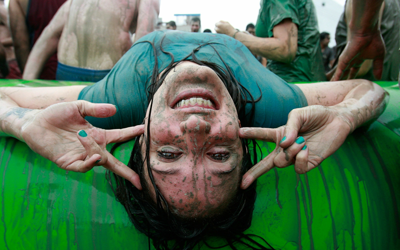 A participant poses in a mud pool during the event, which promises to get your very, very dirty. It ends on July 25. (GETTY IMAGES)