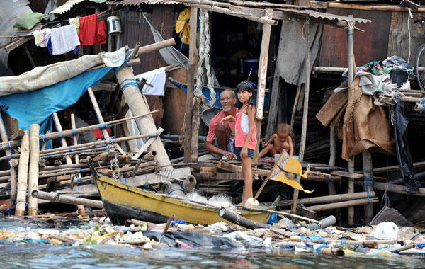 Filipino makes repairs to his shanty home after it was damaged by Typhoon Conson along a brake water in Manila.Troops scoured jagged coastlines on the Philippines' eastern seaboard in search of dozens of fishermen who went missing after a ferocious typhoon battered the country, killing 23 people. (AFP)