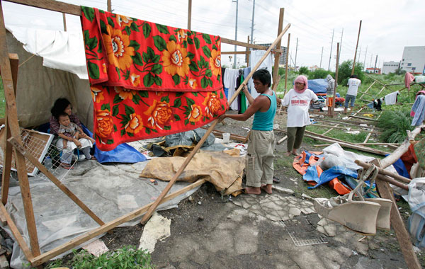A Filipino Muslim family rebuilds their shanty after it was torn down due to strong winds from Typhoon Conson in Makati, south of Manila, Philippines The first typhoon to lash the Philippines this year killed several people and left some 11 others missing Wednesday after flooding streets in the capital and toppling power lines.(AP)