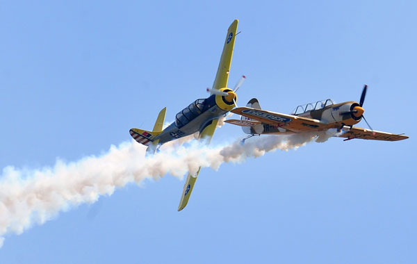 Romanian pilots flying IAK52 airplanes cross trajectories during an aerobatic demonstration at the Otopeni Air Show 2010, near Buchares. (AFP)