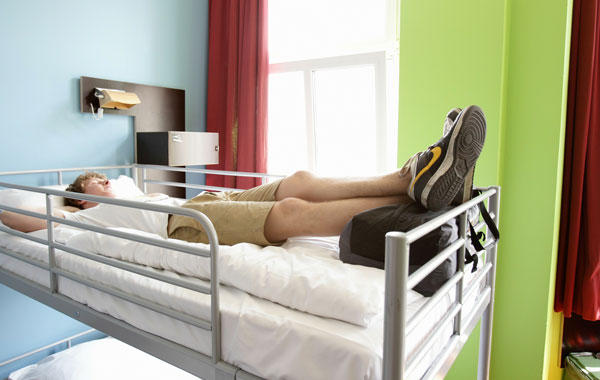 A youth british backpacker rests on a bed at the Circus hostel Berlin, Germany. Millions of youth people taking a gap year between high school and college to see the world. Backpacking is the cheapest way to travel the world.  (Getty Images)