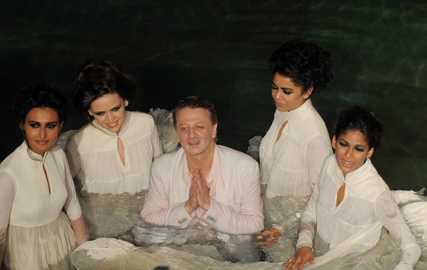Top Indian designer Rohit Bal (centre) poses with models in a swimming pool after presenting his creations during the  Pearls Delhi Couture Week 2010. (AFP)