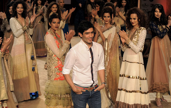 Bollywood designer Manish Malhotra (centre) acknowledges the crowd after presenting his creations during the Pearls Delhi Couture Week 2010 on Tuesday. (AFP)