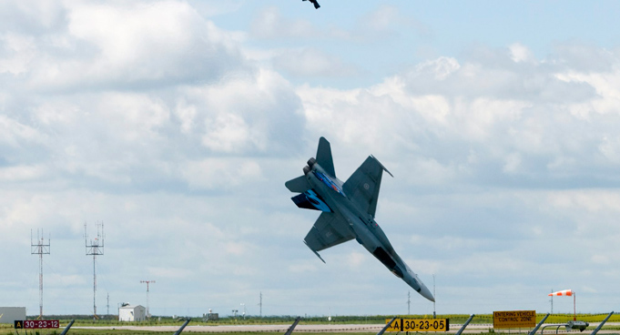 Pilot Capt. Brian Bews parachutes to safety as his a CF-18 fighter jet plummets to the ground during a practice flight at the Lethbridge County Airport on the weekend airshow in Lethbridge, Alberta, Canada. (AP)