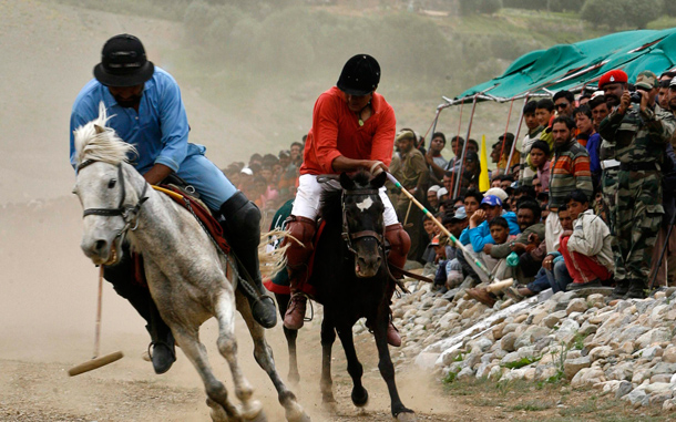 A player of the Ladakh Scouts Regimental Centre (red) and a player from the Polo Club Drass (blue) fight for the ball during a horse polo match as part of ceremonies remembering the Kargil War in Indian-administered Kashmir. (REUTERS)