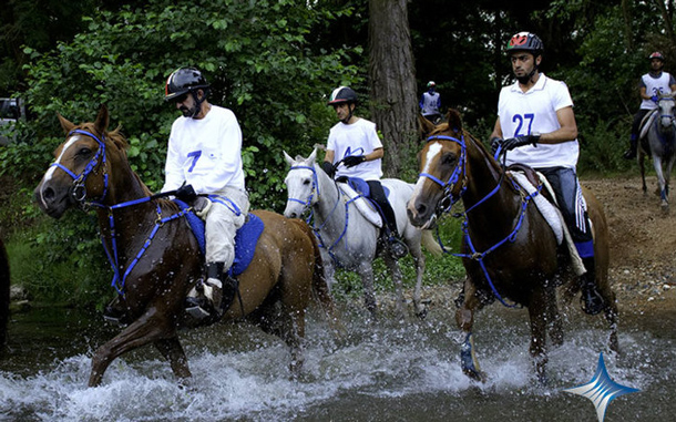 Sheikh Mohammed guides his horse across a river. (SUPPLIED)