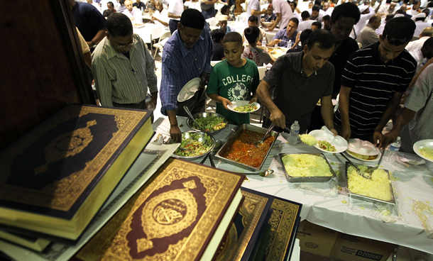 Muslims line up for food as they break fast after sunset at Dar Al-Hijrah Islamic Center in Falls Church, Virginia. Muslims around the world started their first day of fasting to observe the month long Ramadan.(AFP)