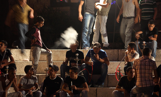 Palestinian young men gather on the steps at the Damascus Gate in East Jerusalem and smoke water pipes as they celebrate after breaking the first day of fasting for the Muslim holy month of Ramadan. (EPA)