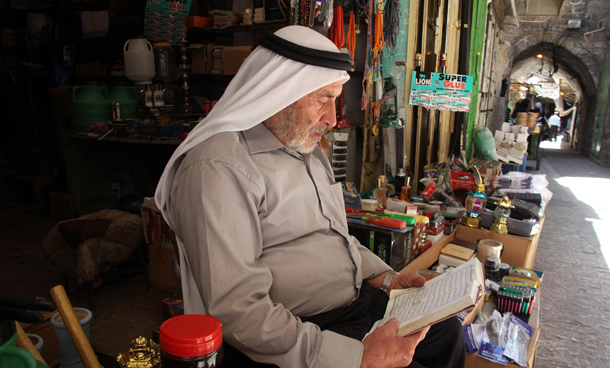 A Palestinian man reads the Koran, Islam's holy book, as he sits in front of his shop in the old city of Hebron, in the West Bank. In Hebron, the West Bank. Ramadan is the ninth month of the Islamic calendar, a month of fasting, in which participating Muslims refrain from eating, drinking and sexual activities from dawn until sunset. (EPA)
