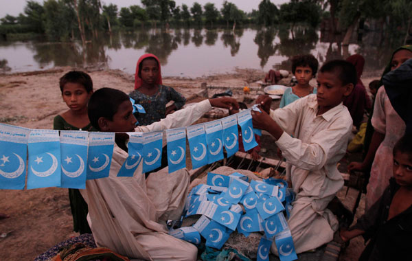 Displaced Pakistani flood affected children make preparations to celebrate the Independence Day of Pakistan in Qadirpur, 120 kilometers (74 miles) from Sukkar, Pakistan. (AP)