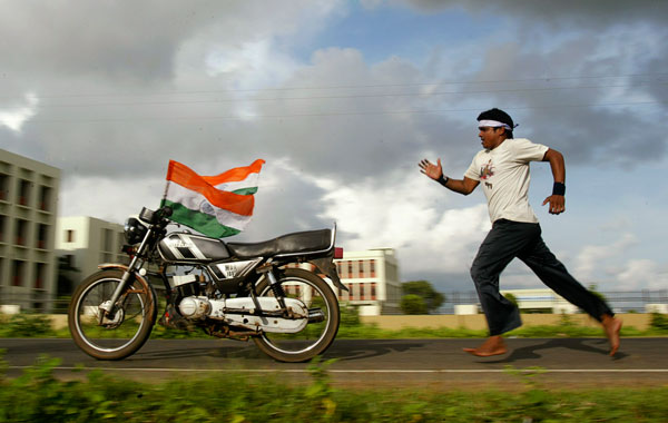 Ekan, 30, chases his bike adorned with Indian national flags as he practices stunts at the Bhuabneswar-Puri national highway ahead of the dare devil show. (AP)