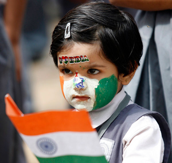 A schoolgirl, with her face painted in colours of the Indian national flag, holds a flag during Independent Day celebrations inside her school in the western Indian city of Ahmedabad. (REUTERS)