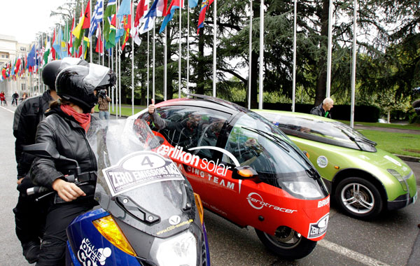 Electric vehicles from the Vectrix Team from Germany, left, Oerlikon Solar Racing Team from Switzerland, center, and Team Trev from Australia, right, pose prior to the start of the Zero Race Tour in the flags alley at the European headquarters of the United Nations, in Geneva, Switzerland. (AP)