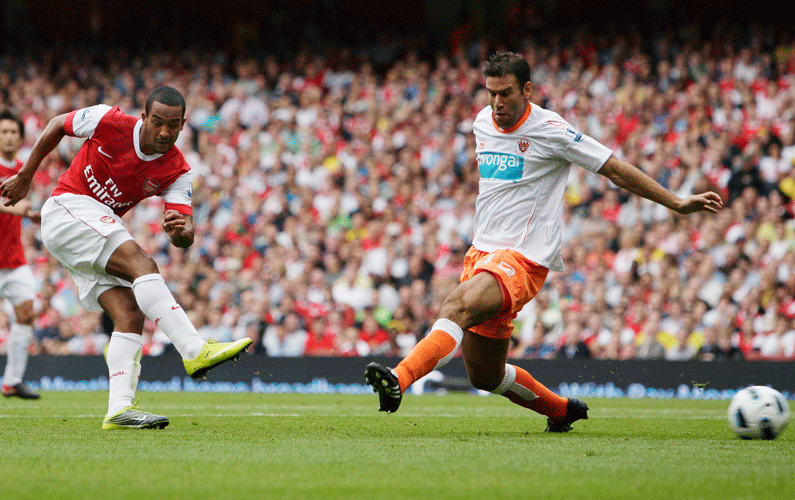 Theo Walcott, left, scores his second goal of three during the English Barclays Premier League football match between Arsenal and Blackpool at the Emirates Stadium, London, on Saturday. (EPA)