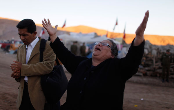 People pray at the camp where relatives of 33 trapped miners wait outside the collapsed San Jose mine in Copiapo, Chile. (AP)
