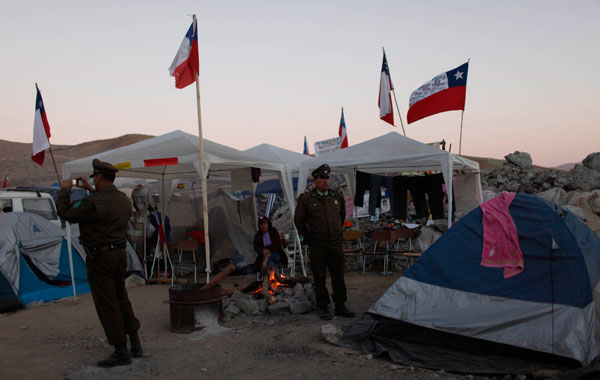 Police officers guard a camp where relatives of 33 trapped miners wait outside the collapsed San Jose mine in Copiapo, Chile. (AP)