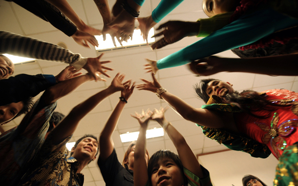 Indonesian singer Hudson Prananjaya (R-in red top), who splits his character into two personalities - Hudson (on the left side, singing in a baritone voice) and Jessica (on the right side, singing in soprano), joins hands with other contestants prior to the final of the "Indonesia Mencari Bakat" television program or Indonesia's version of "Britain's Got Talent", in Jakarta. (AFP)