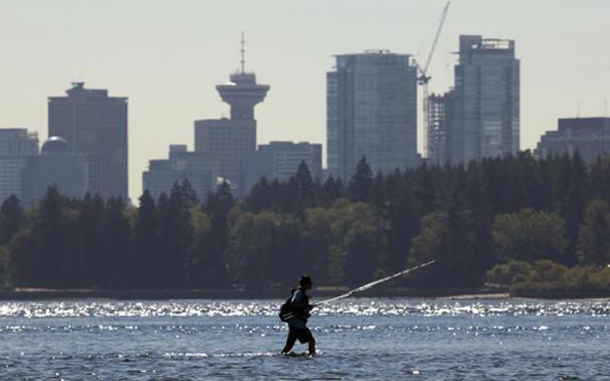 A fisherman wades across the mouth of the Capilano River fishing for salmon in West Vancouver, British Columbia. The Pacific Salmon Commission announced it expects as many as 25 million fish will return the largest return since 1913. (REUTERS)