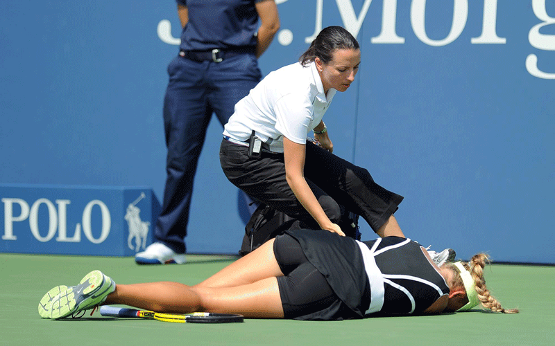 A medical worker rushes to the aid of Victoria Azarenka of Belarus after she collapsed on the court as she played Gisela Dulko of Argentina (unseen) during their second round match at the 2010 US Open Tennis Championship at the USTA National Tennis Center in Flushing, Meadows, New York. (EPA)
