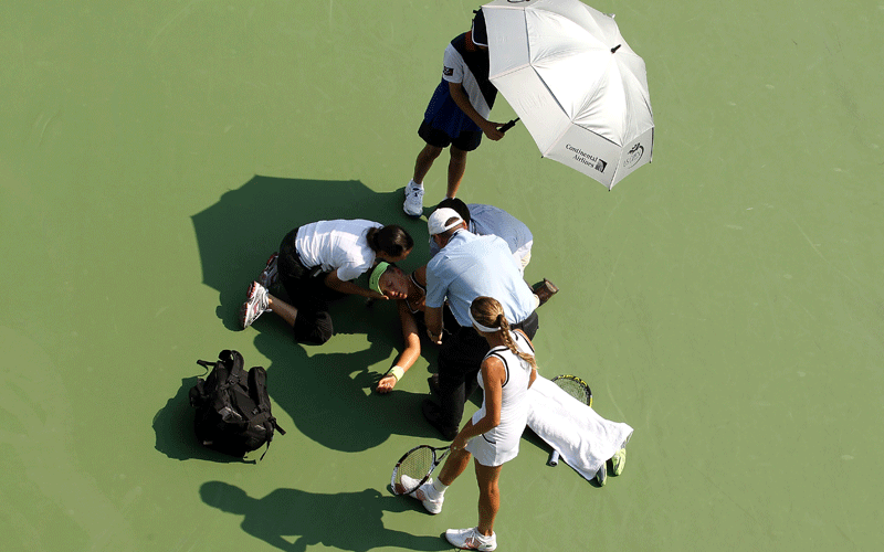Victoria Azarenka of Belarus is tended to by medical ersonnel on the court after she collapsed during her second round women's singles match against Gisela Dulko (seen standing at the bottom of the frame) of Argentina on during day three of the 2010 U.S. Open at the USTA Billie Jean King National Tennis Center on September 1, 2010 in the Flushing neighborhood of the Queens borough of New York City. (AFP)