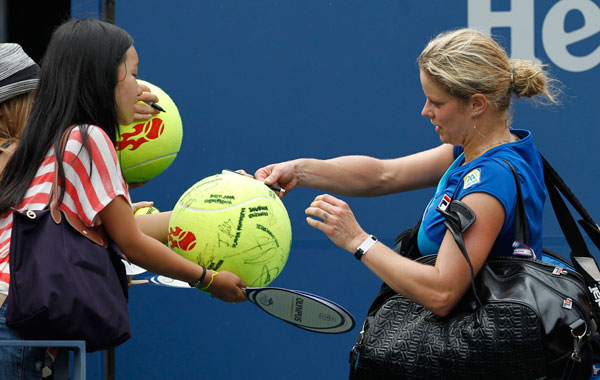 Kim Clijsters of Belgium signs autographs as she leaves the court after beating Petra Kvitova of Czech Republic at the U.S. Open tennis tournament in New York. (AP)