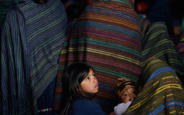 Quiche indigenous children sit with their parents at a funeral mass for mudslide victims in Santa Maria Ixtahuacan, Guatemala. Torrential rains from a tropical depression caused landslides that have killed at least 38 people in Guatemala. (AP)