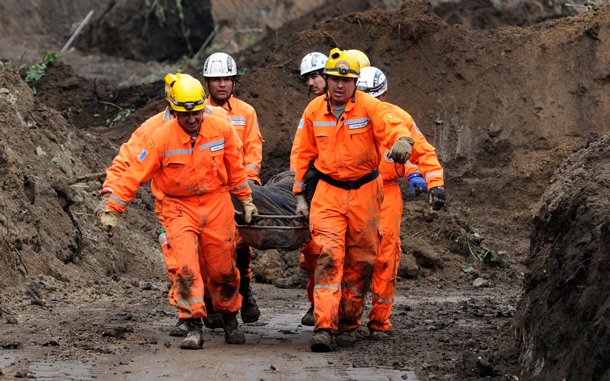 Rescue workers carry a landslide victim on a stretcher in La Cumbre de Alaska. As many as 100 people may have been buried in a landslide in Guatemala on a major highway, a spokesman for the fire department said on Sunday. Approximately 100 people were attempting to dig a bus out of a first mudslide when a second engulfed the scene, said fire department spokesman Sergio Vasquez. (REUTERS)