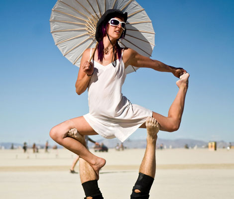 Participants perform a routine of strength and endurance Wednesday afternoon on the open playa during Burning Man 2010 in Black Rock City. (AP)