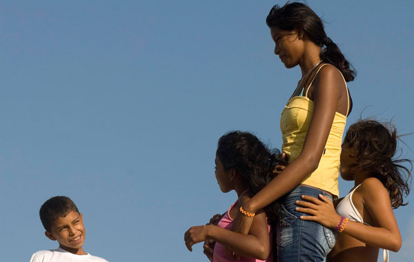 Fourteen-year-old Elisany Silva (2nd R), who measures 2.06 meters (6'9") tall, and her sisters Talicia (R) and Eliza talk with a friend in Braganca in the Brazilian Amazon state of Para. (REUTERS)