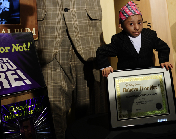 Khagendra Thapa Magar, the world's smallest teen, stands next to a life-sized figure of Robert Wadlow, the world's tallest man ever, to mark his introduction into "Ripley's Believe It or Not" latest book during a photo shoot on Times Square in New York. The Nepalese 17-year old made his entry into the record book as the world's smallest male teen standing just 55.9 centimetres (22 inches) tall. (AFP)