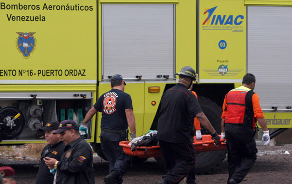 Firemen and rescue members work on the site where a plane of Venezuelan Conviasa company crashed in Ciudad Guyana, Venezuela. (EPA)