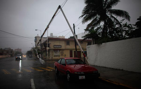 A damaged lamp post dangles above a car after strong winds in Veracruz September 17, 2010. Hurricane Karl bore down on Mexico's central Gulf Coas. (REUTERS)