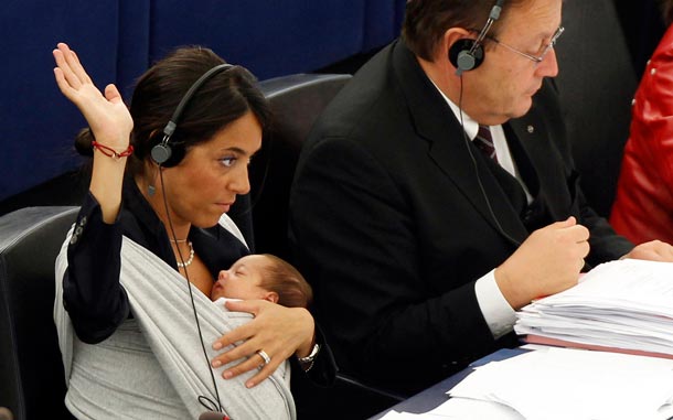 Italian Member of the European Parliament Licia Ronzulli, left, takes part in a vote as she cradles her baby at the European Parliament in Strasbourg eastern France. (AP)