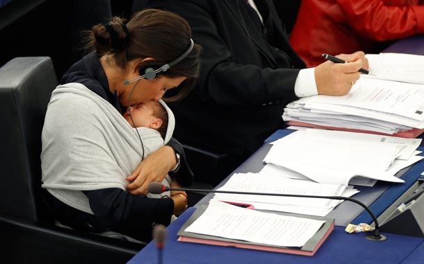 Italy's Member of the European Parliament Licia Ronzulli kisses her baby as she takes part in a voting session at the European Parliament in Strasbourg. (REUTERS)