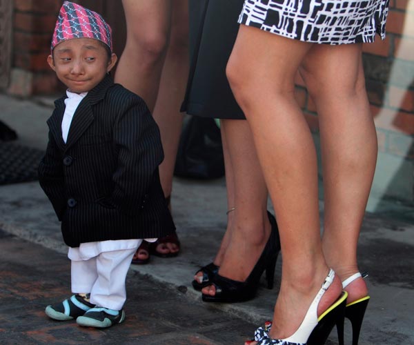 Khagendra Thapa, who is expected to be the world's shortest man next month when he turns 18, looks at the legs of Miss Nepal beauty pageant winners during a news conference in Kathmandu. (REUTERS)
