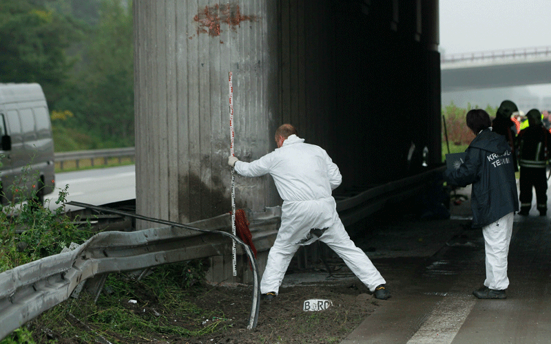 An investigator takes a measurement at a concrete bridge support where a tour bus crashed on the A10 highway near Berlin, Germany. According to police on site at least 11 people were killed and 7 seriously injured. (GETTY IMAGES)