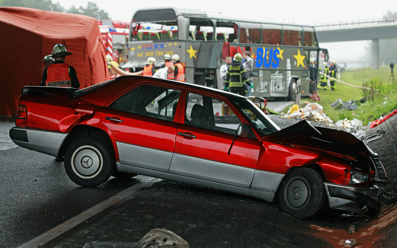 Firemen and rescue workers stand around a smashed Mercedes car and a tour bus that crashed into a concrete bridge support on the A10 highway near Berlin, Germany. According to police on site at least 11 people were killed and 7 seriously injured. (GETTY IMAGES)