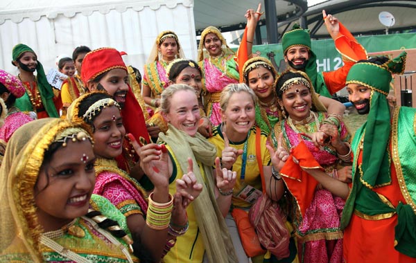 Australian Athletes Megan Rivers (center left in yellow) and Fiona Johnson (center right in yellow) pose with Indian school children after they attend the flag hoisting ceremony of Australia at the International zone of the Commonwealth Games Village   in New Delhi, India. (EPA)