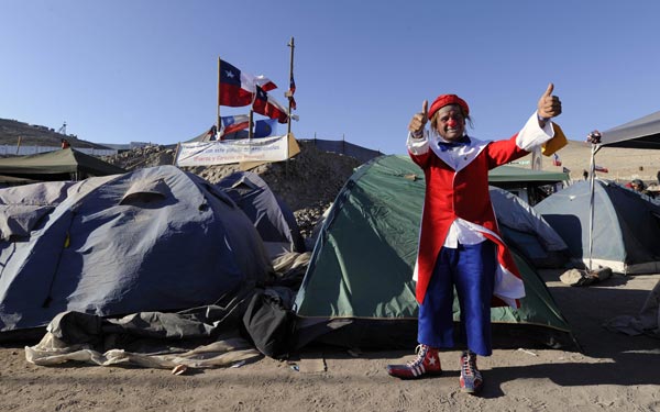 Rolly the Clown gives his thumbs up next to tents of Esperanza camp, at the San Jose mine near the city of Copiapo, 800 km north of Santiago. (AFP)