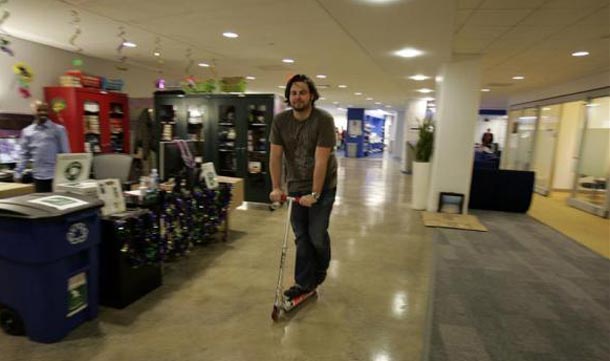 An employee rides a company scooter along the corridors at the New York City offices of Google. (REUTERS)
