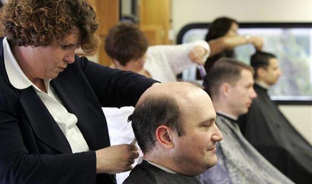Dena Kaufer, owner of Onsite Haircuts, cuts the hair of a Google employee inside her refitted Winnebago in the parking lot of Google headquarters in Mountain View. (REUTERS)