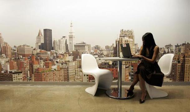 A Google employee works on a laptop in front of a mural of the New York City skyline at the New York City office of Google. (REUTERS)
