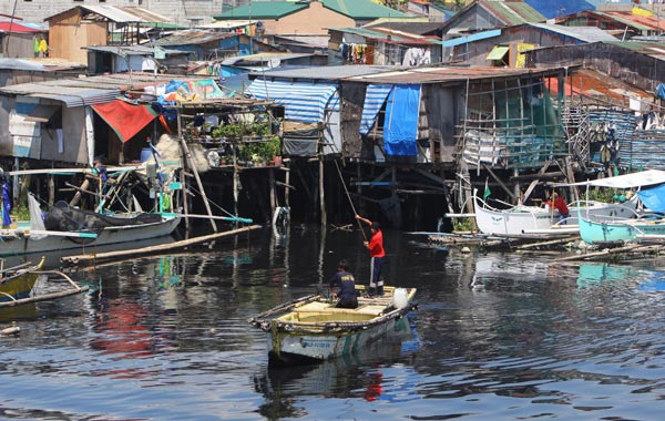Filipinos maneuver their boat from a coastal fishing community in Navotas, north of Manila, Philippines. (EPA)