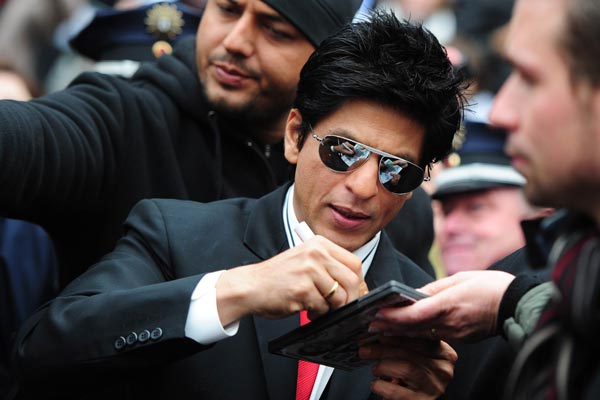 Indian Bollywood actor Shah Rukh Khan (C) signs autographs after a press conference on the shooting of her movie "DON-2". (AFP)