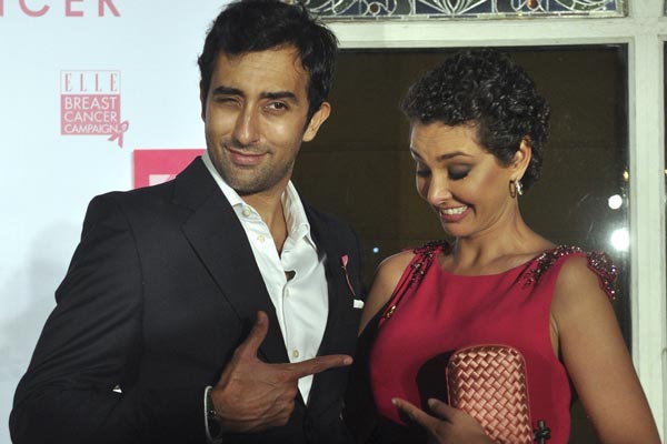 Indian Bollywood actor Rahul Khanna (L) gestures to Indian model Lisa Ray as they pose while attending a promotional event on breast cancer awareness in Mumbai. (AFP)