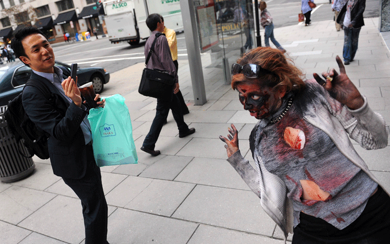 An actress portraying a zombie poses for a picture to promote the new TV series "The Walking Dead" on the AMC channel on October 26, 2010 outside the Metro Center subway entrance in Washington, DC. (AFP)